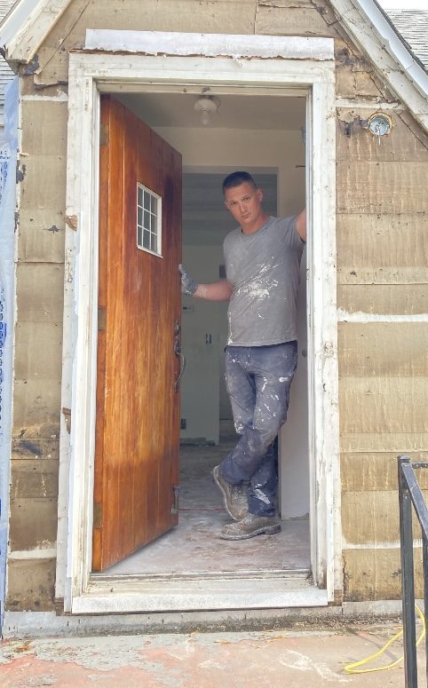 Ben Guse on a jobsite, mid-renovation, replacing an exterior door frame.